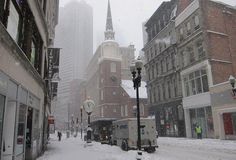 a city street is covered in snow with tall buildings