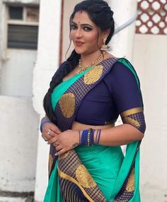 a woman in a blue and green sari