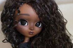 a close up of a doll with curly hair