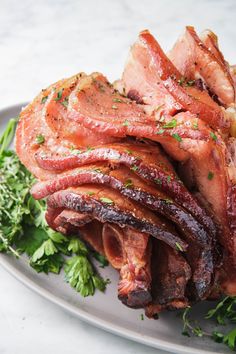 bacon wrapped in herbs on a plate with parsley and seasoning sprigs