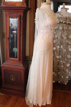 a dress on display in front of a grandfather clock