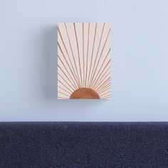 the sun is shining brightly on this wall mounted art piece in an otherwise empty room