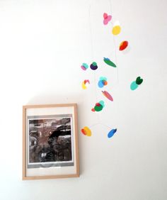 a photo hanging on the wall next to a frame with paper circles attached to it