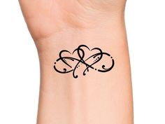 a small tattoo on the wrist of a woman's left arm, with an intertwined