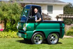 a man sitting in the bed of a green truck with jacked up written on it