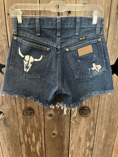 Wrangler Bleached "BULL SKULL" Cut Offs are super cute !! The Bleached "Bull Skull" & SV  logo patch are def to get heads turning!! These are a size 27 in Men's , they are the 13MWZ style! ( Most would be a 23-24 in a women's jean .. they are considered XS)  ** The 13MWZ Style does not stretch**  ** MEASURE YOUR WAIST STRAIGHT ACROSS THE WAIST OF JEANS LAID FLAT - TAKE THAT NUMBER AND TIMES BY 2 ! THESE ARE 13.5x2 =27! ** ** In calculating sizes you may need to go up 3-4 sizes ** ( EX: IF YOU ARE A 24 and go up 3 sizes you would be a 27 in Men's Wranglers)  ( Give or take , this is a base for which you can calculate as close to your size as possible) !! ** Can machine wash on gentle cycle inside out / hang to dry**  ** DO NOT PUT IN HOT DRYER** ** BLEACHED BULL SKULL WILL FRAY IN HOT DRYER Sv Logo, Bull Skull, Cut Offs, Bull Skulls, In Hot, Cut Off, Short Outfits, Patch Logo, Favorite Outfit