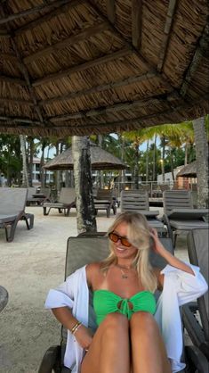 a woman sitting in a chair on the beach