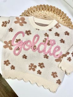 Our custom hand embroidered name sweaters are sure to look adorable on the sweet little one in your life!  Give them as gifts for baby showers, name announcements, first birthday's, Xmas gifts, and more!  Sweaters are a chunky knit and an oversized fit to wear as your baby grows.  These are perfect to wear in the fall, winter, or spring. Choose how many letters are in the name you want embroidered.  Fill in the personalization box with the name and thread color of your liking. Care Instructions White Letter Embroidery Sweater For Winter, Cute Cream Crew Neck Sweater, Cute White Embroidered Sweater, Cream Long Sleeve Sweater With Letter Embroidery, Cute Cotton Sweater With Embroidered Logo, Cute Cotton Sweater With Floral Embroidery, Pink Winter Sweater With Embroidered Logo, Cute Winter Sweater With Letter Embroidery, Cute Winter Sweater With Embroidered Text