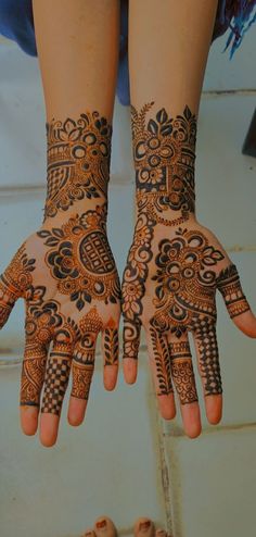 two hands with henna designs on them