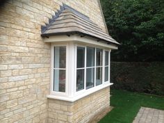 a brick building with a white window and tiled roof