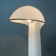 a lamp that is on top of a white pole with a blue sky in the background