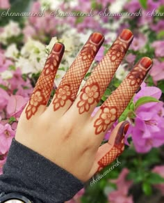 a woman's hand with hennap on it and flowers in the background