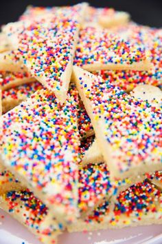 sprinkle covered cookies are arranged on a plate