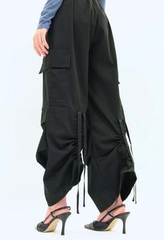 One size. fits xs-m  color: black  pockets  cargo pockets  darting at hem  cinched on the back  100% nylon  dry clean  by the nkc store    product measurements:  length: 101.6cm / 40in  waist: 60.96-81.28cm / 24-32in  inseam: 69cm / 27in    model is 177cm / 5'10" wearing size o/s Gothic Bottoms With Pockets For Streetwear, Gothic Cotton Streetwear Bottoms, Black Techwear Bottoms With Patch Pockets, Gothic Streetwear Bottoms With Pockets, Techwear Wide-leg Bottoms With Cargo Pockets, Class Ideas, Trousers Women, Trousers, Dry Clean