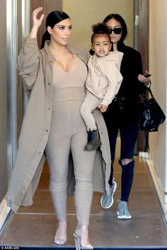 kim kardash and her daughter are walking down the hallway