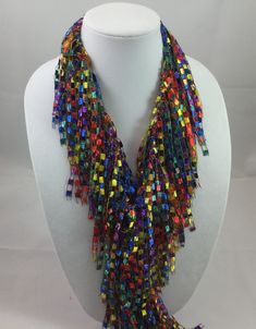 A beautiful and unique handmade accessory that shimmers and portrays a beaded look! Each Infinity Scarf Necklace is handmade and can be worn multiple ways. Item is lite weight and is available in many stunning great colors. Comes packaged in an organza bag. A great gift item. Each Infinity Scarf Necklace is a continuous loop approximately 66 inches in circumference and is made of 97% Nylon and 3% Lurex. Hand wash in cold water and lay flat to dry. Each item is made by hand and slight variations Party Long Beaded Chain Necklaces, Party Long Beaded Necklaces, Adjustable Multicolor Necklaces For Party, Adjustable Multicolor Necklace For Party, Long Beaded Necklace For Party, Long Necklace With Colorful Beads For Party, Unique Party Necklaces With Faceted Beads, Unique Necklace With Faceted Beads For Party, Unique Faceted Bead Necklaces For Parties