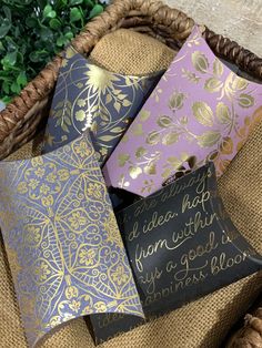 four decorative pillows sitting in a basket