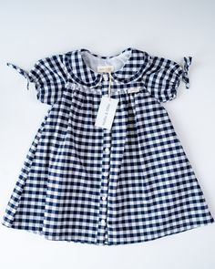 Our gorgeous new Carrie dress is fully lined and 100% cotton. It is available in Blue and White French Floral, Blue and White Gingham and Blue and White Ticking Stripe. The very cute puff sleeve is finished off with a lovely bow and the collar is beautifully edged with a small frill. This is such a versatile little dress to take on holiday, it can so easily be dressed up or down and is perfect for tea parties, going out to lunch or dinner or just playing in the countryside or seaside. And just throw on a cardigan for those cooler days, infact this little dress could carry through to the winter months if you add stockings, wellies and a winter coat. Limited stock in each size and colourway so be sure you don't miss out. Spring Blue Plaid Cotton Dress, Cute Short Sleeve Cotton Plaid Dress, Cute Short Sleeve Plaid Cotton Dress, Short Sleeve Cotton Plaid Dress For Spring, Short Sleeve Cotton Plaid Spring Dress, Cotton Gingham Plaid Dress With Ruffles, Gingham Plaid Cotton Dress With Ruffles, Spring Cotton Plaid Dress With Short Sleeves, Preppy Plaid Cotton Dress