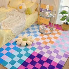 a colorful rug on the floor in front of a bed with pillows and stuffed animals