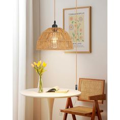 a white table and chair in a room with a light hanging from the ceiling over it