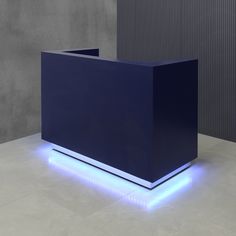 an illuminated blue counter in front of a gray wall with vertical lighting on the sides