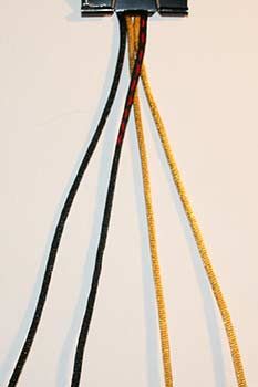 three wires connected to each other on top of a white wall with black and yellow cords