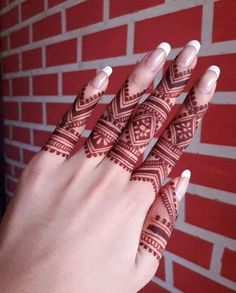 a woman's hand with henna tattoos on it