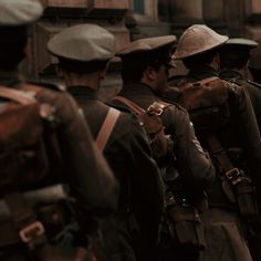 a group of men walking down a street next to each other wearing hats and backpacks