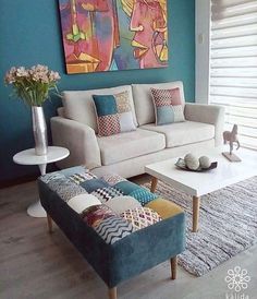 a living room with a couch, coffee table and painting on the wall behind it