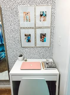 a white desk with pictures on it and a laptop sitting on top of the table