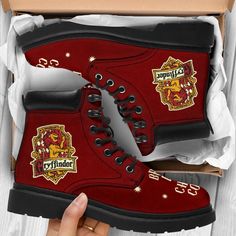 a pair of red harry potter boots with hogwart's crests on them