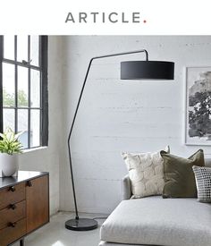 a living room filled with furniture and a large lamp on top of a white wall