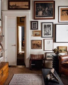 a living room filled with furniture and pictures on the wall