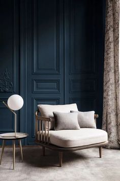 a living room with dark blue walls and white furniture, including a couch in the middle