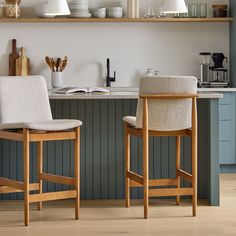 two chairs sitting next to each other in front of a counter top with books on it