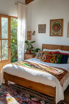 a bed sitting in a bedroom next to a window filled with plants and potted plants