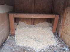 a pile of wood chips sitting inside of a wooden shed next to a wall and floor