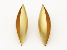 The simple, elegant forms of the Cocoon series are, perhaps, the highest expression of his formal aesthetic. The artist begins with sheet metal and imbues it with a soft and organic volume, over which light softly plays. This subtle interpretation of an elegant, organic form becomes sculpture on the body. His handmade pods are beautiful and revolutionary at once, equally alluring as they are architectural. Using an anticlastic technique, Erich hammers flat pieces of metal into unique, three-dime Sculptural Jewelry With Polished Finish For Formal Occasions, Contemporary Polished Earrings For Evening, Contemporary Polished Finish Evening Earrings, Elegant Sculptural Earrings For Formal Occasions, Contemporary Sculptural Jewelry For Formal Occasions, Contemporary Teardrop Earrings, Elegant Sculptural Jewelry With Polished Finish, Elegant Sculptural Jewelry For Formal Occasions, Modern Polished Wedding Earrings