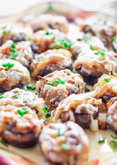 a plate full of mushrooms covered in gravy and garnished with green chives