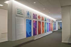 an office hallway with posters on the wall and carpeted flooring in front of it