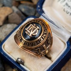 This awesome 1974 class ring from Notre Dame for Boys features an oval green glass stone with a ND plaque in the center. The ring is crafted of 10k yellow gold with a natural unpolished rich patina. This ring is currently a size 7. We are not offering resizing due to the design. The inside of the shank is engraved with the initials KGM. 1990 Class Ring, 1976 Class Ring, Notre Dame College, Black Star Sapphire, Star Sapphire Ring, Championship Rings, Star Sapphire, Black Star, Men's Jewelry