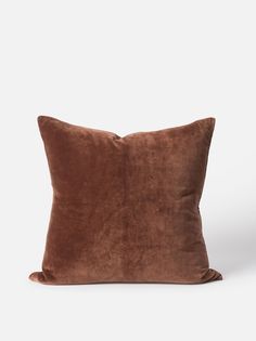 a brown velvet pillow on a white background