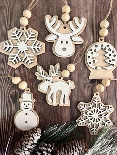 wooden christmas ornaments on a table with pine cones