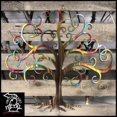 a metal tree sitting on top of a wooden bench