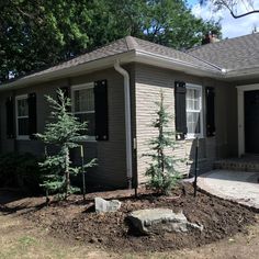 a small house with trees in the front yard