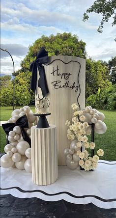 a table topped with balloons and vases filled with flowers