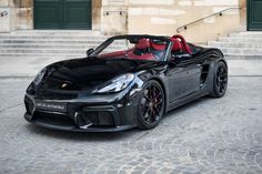 a black sports car parked in front of some steps