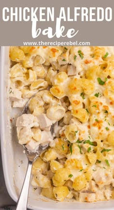 chicken alfredo bake in a white casserole dish with a serving spoon