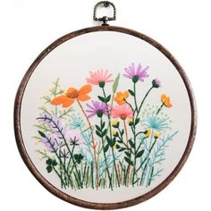 an embroidery kit with flowers in the center and green stems on it's side