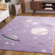 a purple rug with planets and stars on it in front of a white couch next to a tv